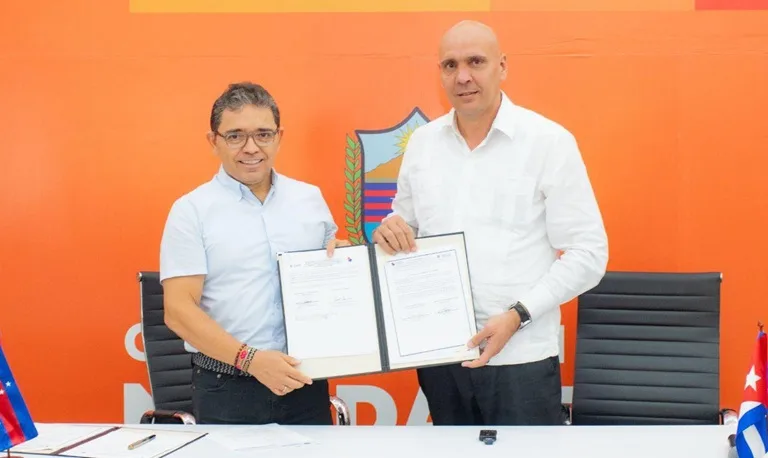 El Gobernador Rafael Martínez y el Embajador Javier Caamaño sostienen el convenio firmado entre ambas entidades.