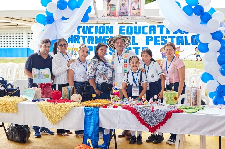 Docentes y estudiantes en su stan del foro