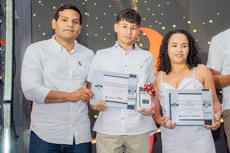 Secretario de Educación encargado entrega premio a estudiante y docente entrenadora.