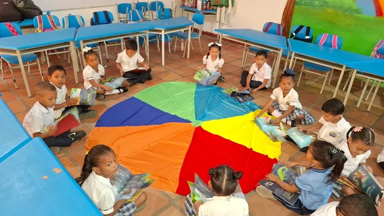 Niños sentados en el suelo leyendo libros
