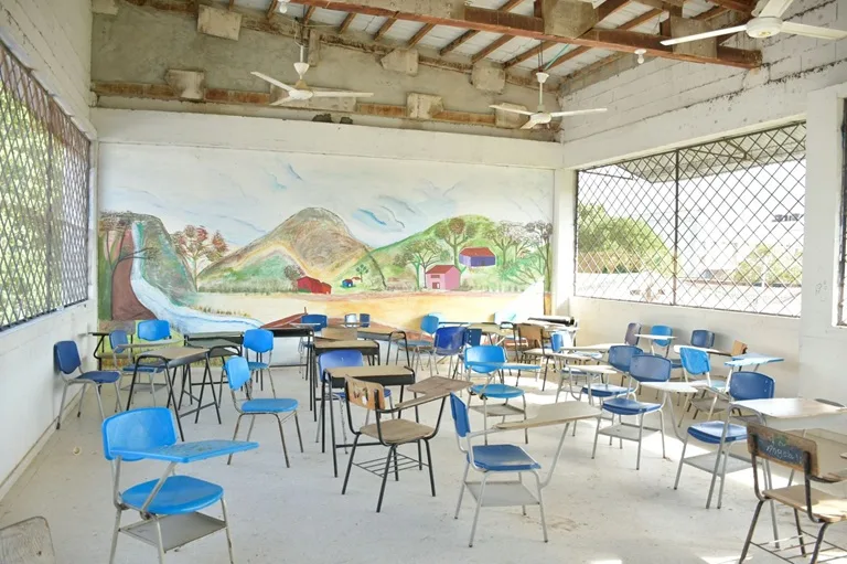 Salón de clases con sillas, abanicos, ventanales, pintado, con mural
