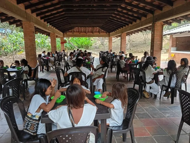 Estudiantes indigenas recibiendo su alimentación