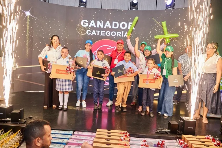 Estudiantes ganadores junto a sus docentes entrenadores en la tarima de premiación