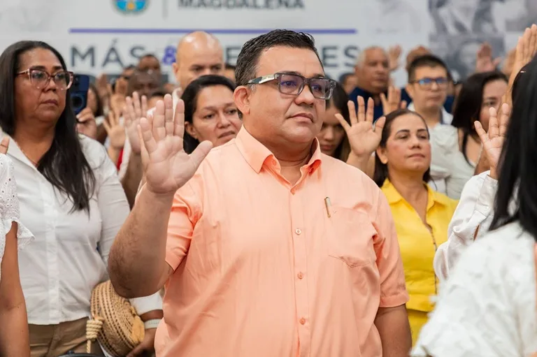 Docentes con la mano levantada toman juramento en su acto de posesión