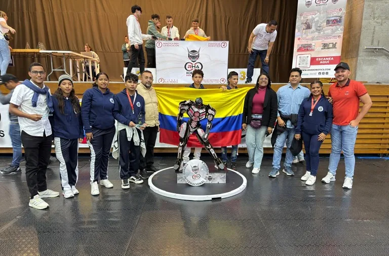 El rector, docente s y estudiantes de la IED San José, de Sitionuevo con la bandera de Colombia en la premiación de torneo de robótica