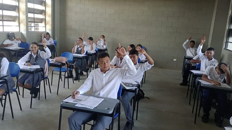 Estudiantes en un salón de clases presentando un simulacro de la Gobernación